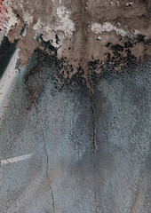 Close-up of old peeling paint on a wall surface. Weathered, cracked and flaking layers create a textured and distressed background.