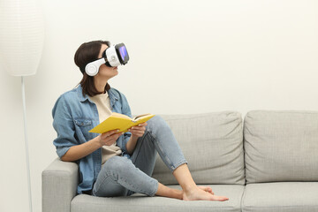 Young woman reading book with VR headset, combining traditional learning and futuristic technology at home