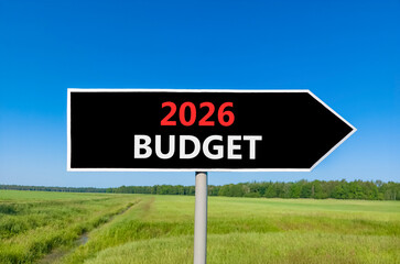 2026 Budget symbol. Concept words 2026 Budget on beautiful black road sign. Beautiful green grass field forest and blue sky background. Business and 2026 budget concept. Copy space.