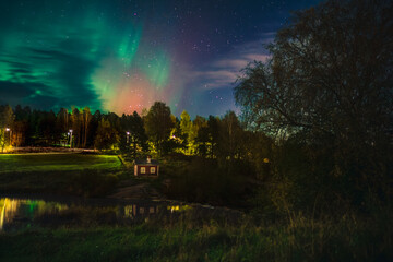 Aurora Borealis Above Riverside Sauna in Finland, Autumn Night