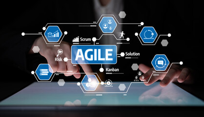 A close-up view of hands interacting with a digital tablet displaying Agile concepts and icons,...