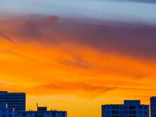 Bright glowing sky over city buildings at sunset