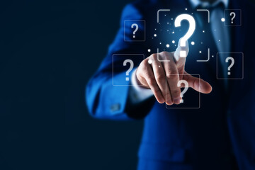 Businessman touching question mark on virtual screen against dark blue background, closeup