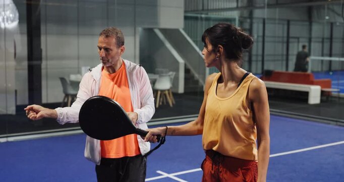 Padel, training or people in club with racket, learning and support in swing practice. Lesson, tennis and coach in court with equipment, grip technique and wrist control in performance advice.