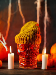 Red Halloween cocktail on a table with burning candles