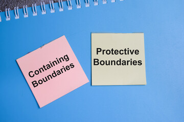 Concept of 2 main types of boundaries. Containing and protective boundaries write on sticky notes isolated on Wooden Table.