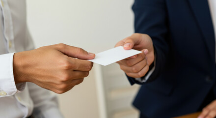 Business card exchange between two young adult males