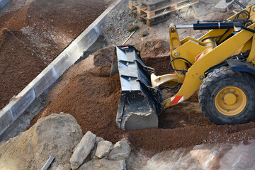Excavator working on construction site moving soil