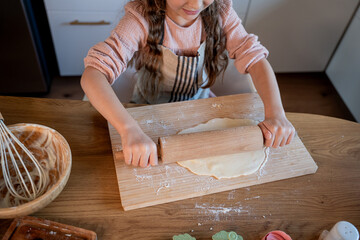 Little cute girl baking cookies in the kitchen. Homemade pastries. Cozy autumn.