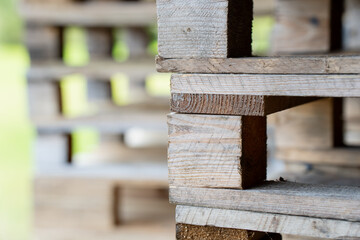 Close-up of stacked wooden pallets used for logistics and storage, showing texture, structure and material pattern representing warehouse organization, transport industry and supply chain equipment