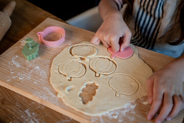 Little cute girl baking cookies in the kitchen. Homemade pastries. Cozy autumn.