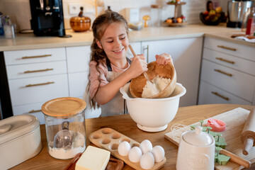 Little cute girl baking cookies in the kitchen. Homemade pastries. Cozy autumn.