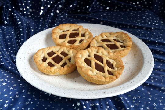 several appetizing cookies with jam on a white plate