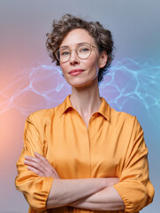 A woman standing confidently with her arms crossed in front of her. She has short curly hair and is wearing glasses.