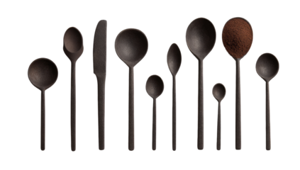 Dark-colored, various-sized spoons and a knife, arranged in a row