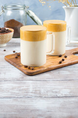 Latte drink with whipped coffee cream on wooden board