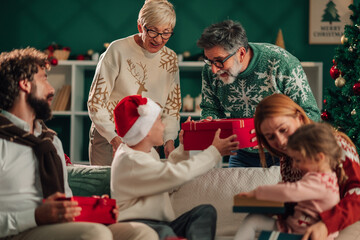 Grandparents giving christmas gifts to grandchildren on christmas day