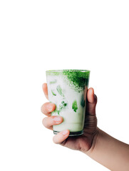 Hand holds a glass of matcha latte