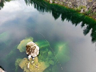 A rock is in the middle of a body of water.