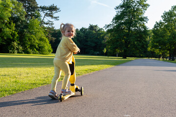 Child riding. Scooter toddler park play. Summer road motion casual sport.