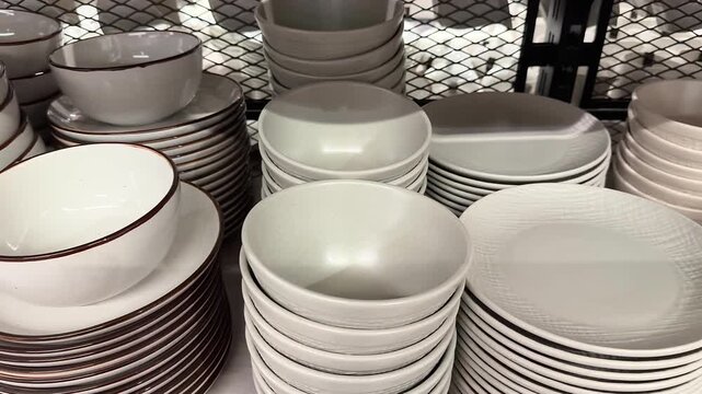 Store shelves displaying piles of ceramic plates and bowls