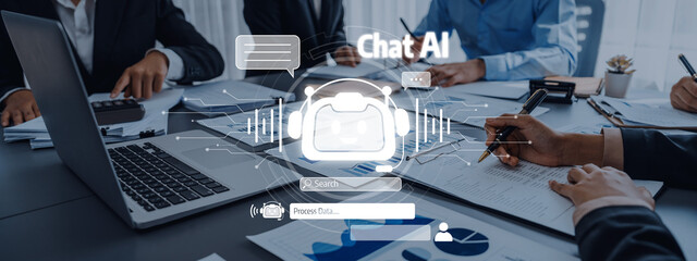 A business team engages in a collaborative meeting to develop an AI chatbot project, surrounded by technology, documents, and a digital interface, reflecting modern workplace dynamics. Trope