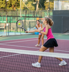 Tennis game &mdash; girl actively kicks the ball during a tennis game