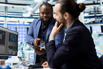 Diverse team of engineering experts discuss workflow strategy and analyzing data in a solar energy factory, reflecting shared responsibility in clean technology and innovation.