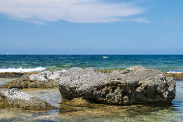 Natural seaside rocks on Malta coast with turquoise waves. Ideal for backgrounds, vacation ads, or design projects focused on marine and coastal themes.