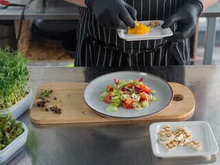 The chef lays out the salad. 