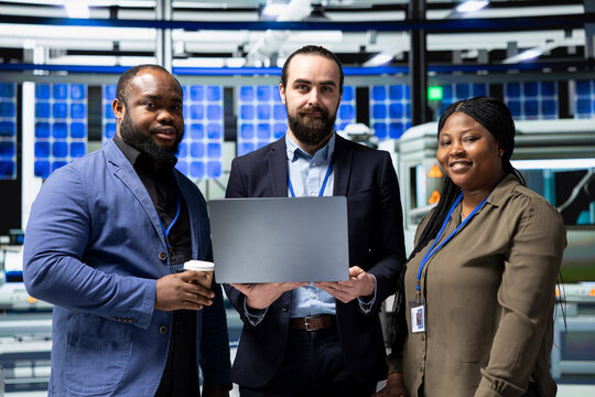 Portrait of diverse master engineers in suits managing solar panel systems as part of a collaborative inspection, ensuring green technology and industrial standards in the production line. - Powered by Adobe