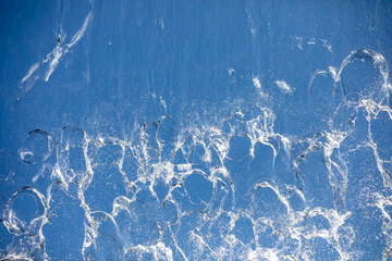 
Falling water on blue background, close-up photo