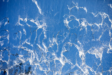 
Falling water on blue background, close-up photo