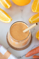 Orange carrot smoothie in a glass. Top view. Healthy vegan blended drink.