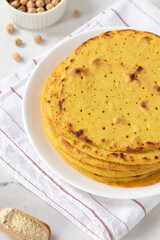 Homemade tortilla wraps with chickpea flour on white kitchen table.