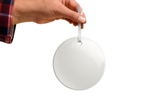 Hand holding Christmas round ceramic ornament or decoration with golden string mockup isolated on a transparent background, PNG. High resolution. Mockup, template ready for your design.