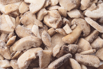 Pile of frozen button mushrooms, sliced and covered with icy frost, natural vegetable background for healthy food, nutrition, vegetarian and vegan cooking concepts.