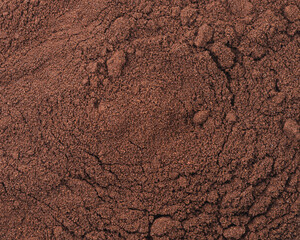 Close-up texture of ground coffee, brown powder background with rich aroma and fine particles, perfect for espresso and brewing concepts.