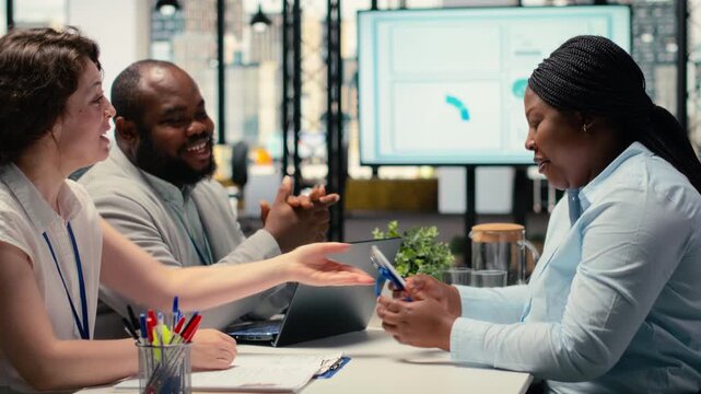 HR team giving ID security card to new hire after the job interview, finalizing the onboarding process and registration after resume and CV approval. Approved candidate. Camera B.