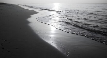 Serene Black and White Beach Scene with Gentle Waves and Sunset Light