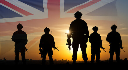 Silhouettes of british soldiers standing in formation against a vibrant sunset with the union jack flag overhead