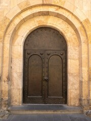 Close view of ancient stone church door with decorative arch in Tbilisi, Georgia.
