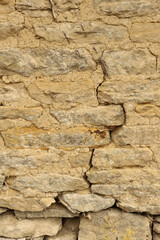 Stone wall showing a rustic texture and background with natural, weathered rock blocks and visible mortar