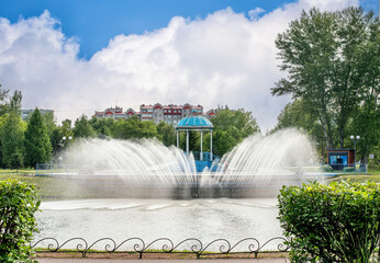 A large, beautiful fountain in the summer park.