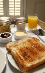 Breakfast tray offering toasted bread, fresh fruit salad, orange juice, jam, and butter. Cotswolds countryside, England