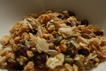 Granola mix showing oats, sunflower seeds, pumpkin seeds, almonds, dried fruit, and coconut flakes. Cotswolds countryside, England