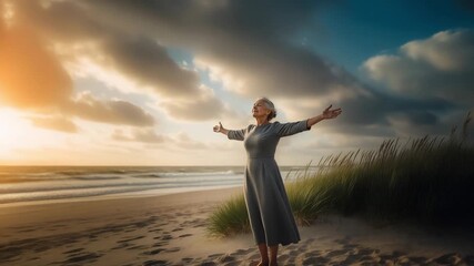 Elderly woman with arms outstretched on a beach at sunset - Powered by Adobe