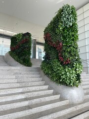 Modern indoor staircase with vertical plant walls and natural greenery design in a lobby space.