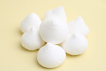 Yummy meringue cookies on beige background, closeup
