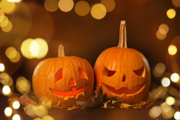 Fototapeta premium Halloween celebration. Pumpkins with carved creepy faces, bokeh effect